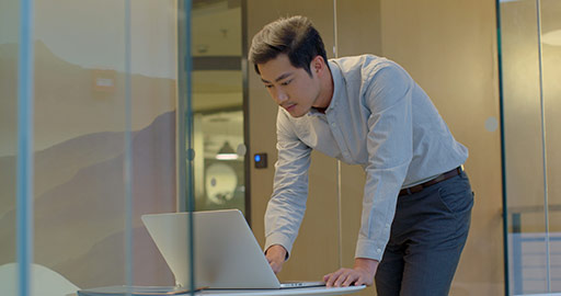 Confident Chinese businessman using laptop in office,4K