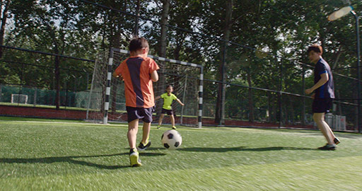 Young Chinese family playing football on soccer field,4K