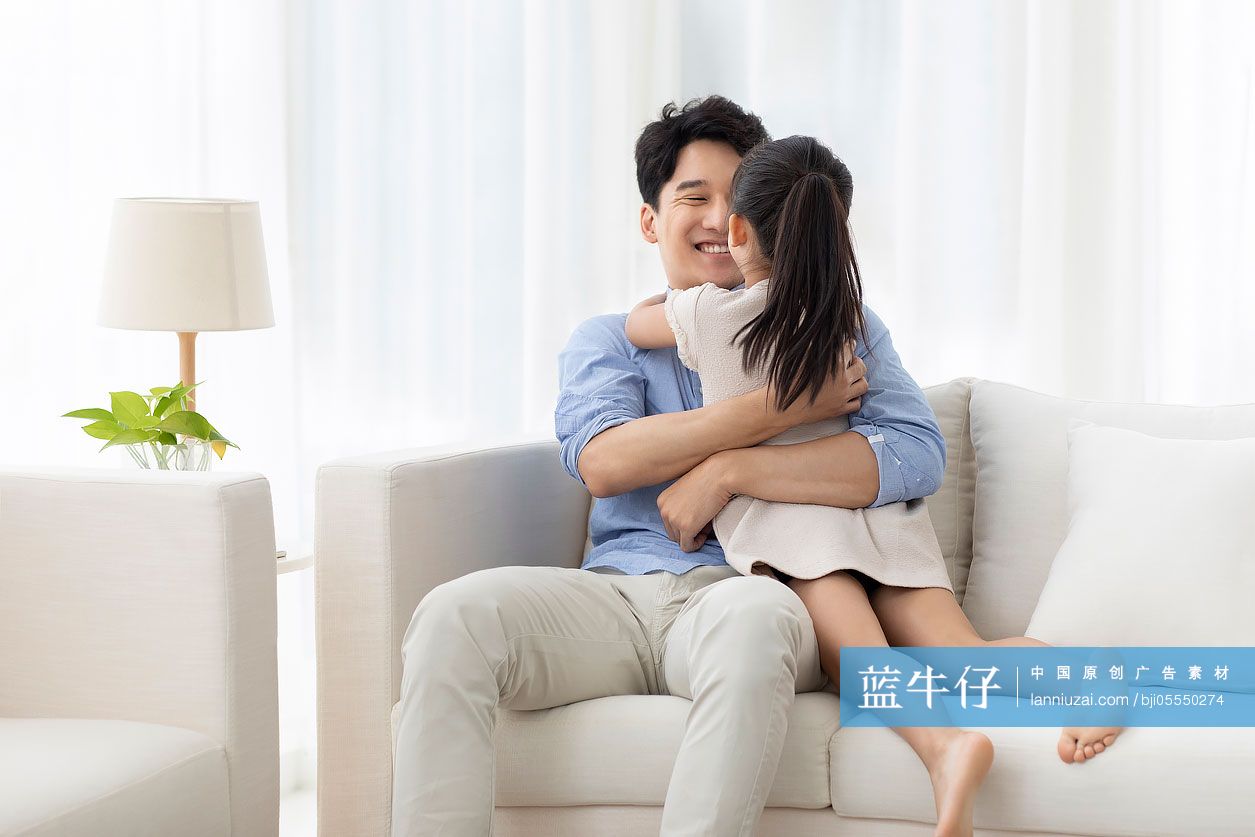 开心的父女俩坐在沙发上
