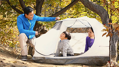 Happy young Chinese family enjoying a camping trip,HD