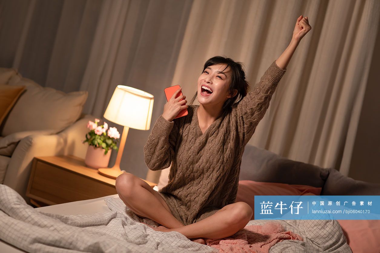 年轻女士在家玩手机游戏