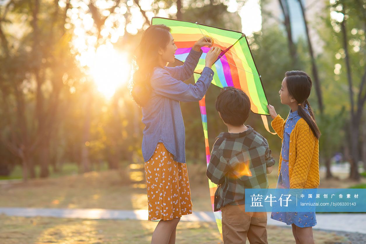 快乐的年轻家庭在公园放风筝
