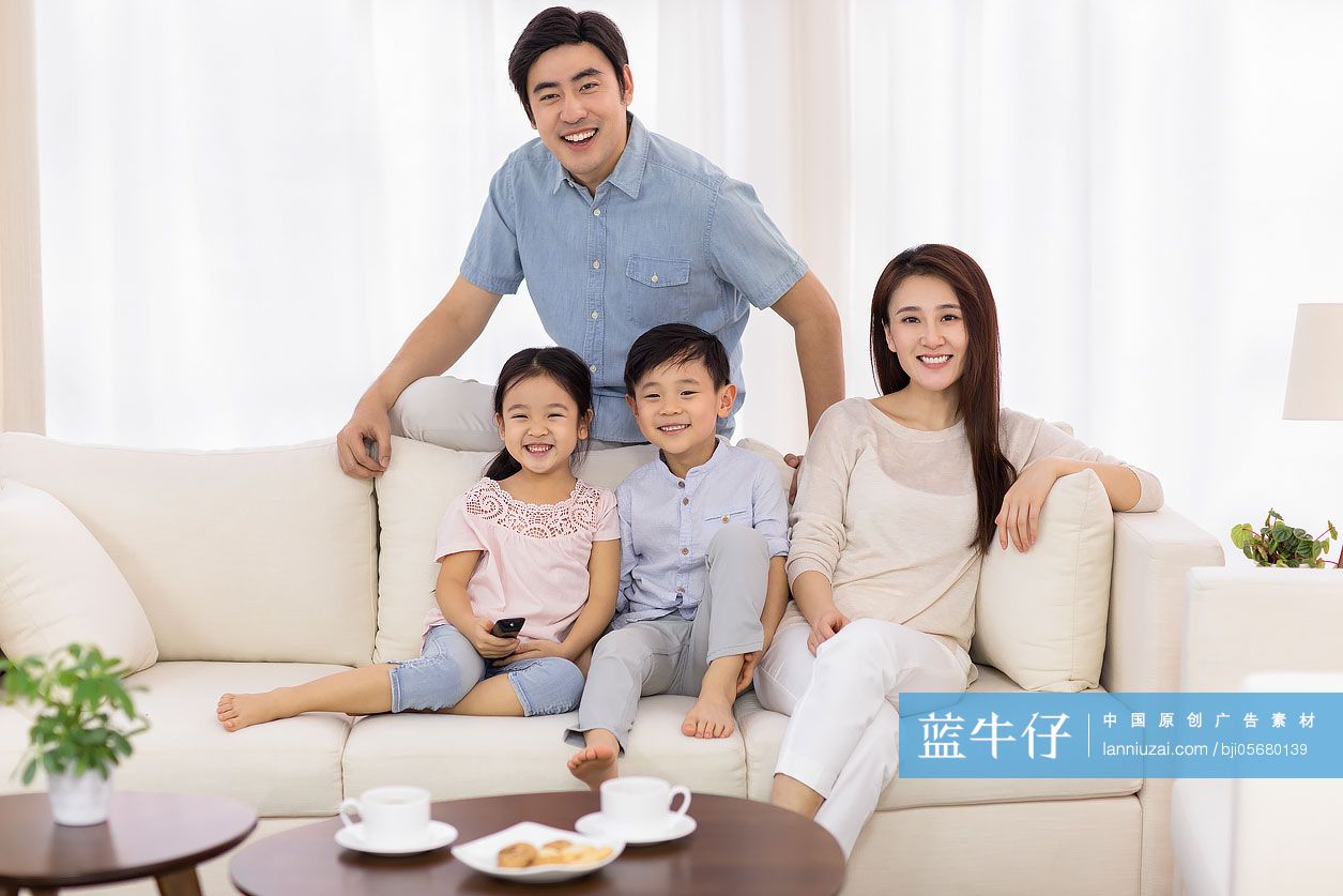 快乐的年轻家庭在客厅看电视