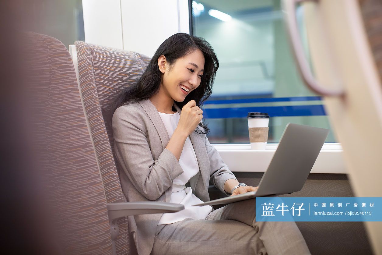 年轻商务女士在高铁上使用笔记本电脑