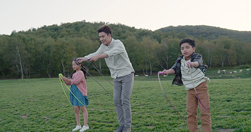 Happy young Chinese family jumping ropes outdoors,4K