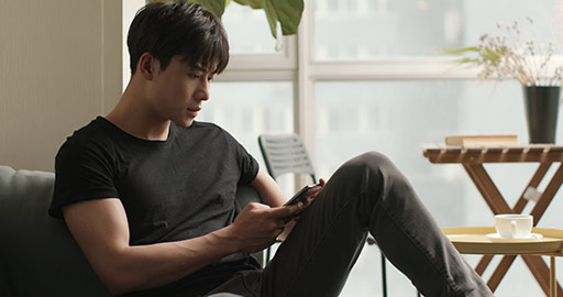 Young Chinese man using smartphone at home,4K