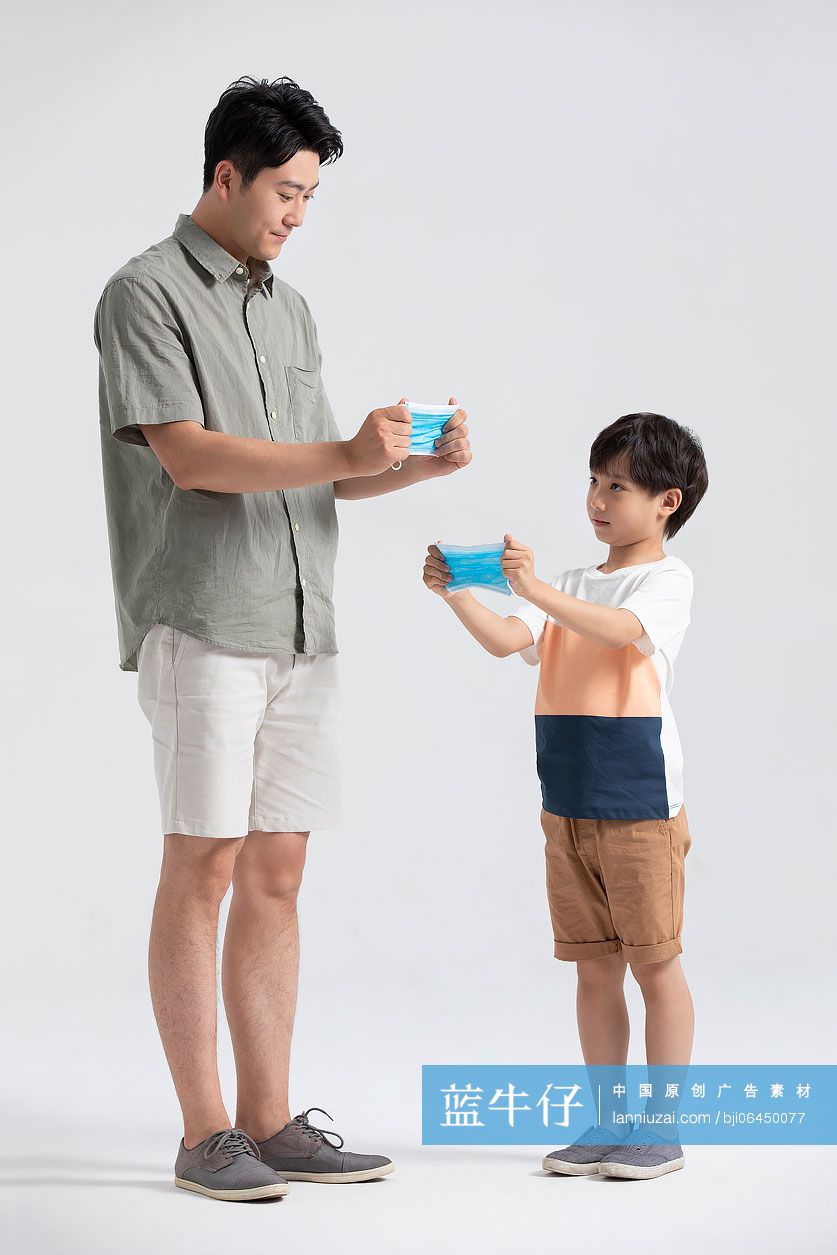 年轻爸爸教孩子佩戴口罩