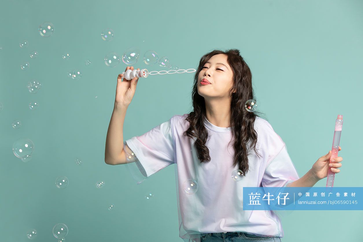 可爱的年轻女孩吹泡泡