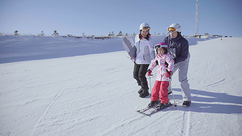 年轻父母教女儿滑雪