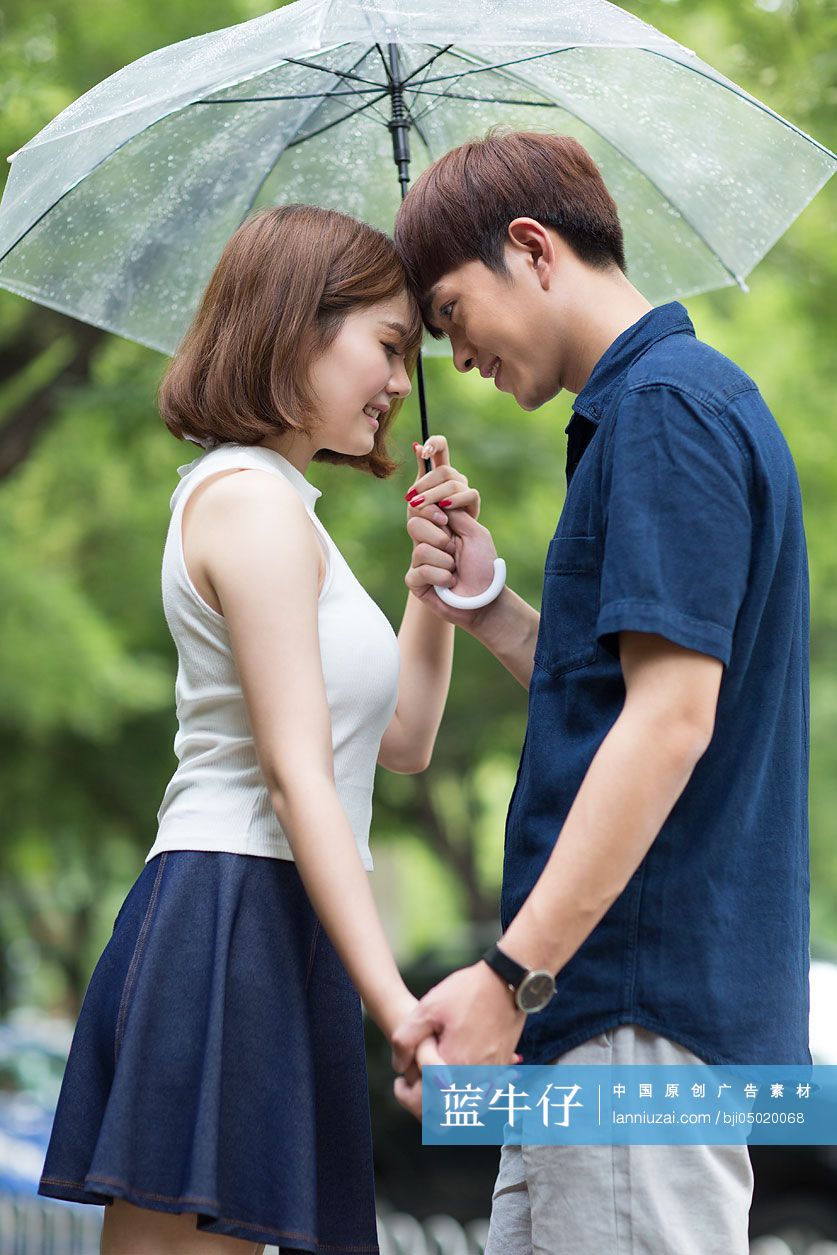 年轻情侣打着雨伞