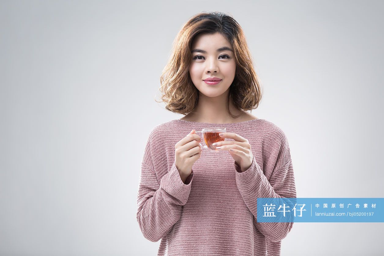 快乐的年轻女子喝红茶