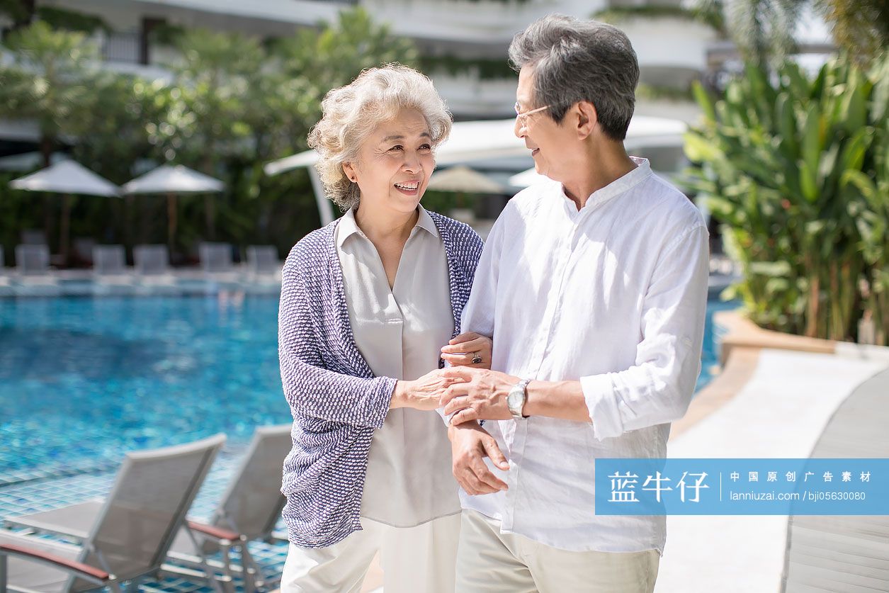 快乐的老年夫妇在泳池边散步