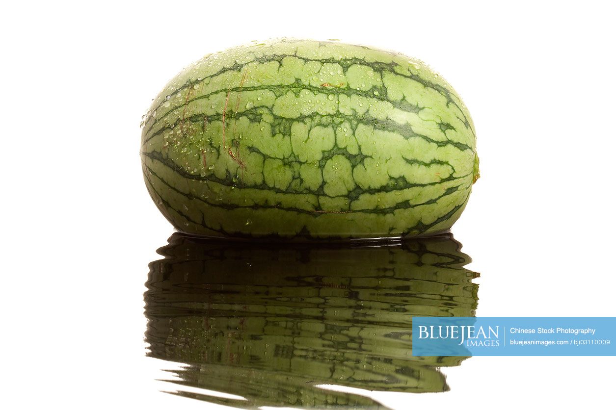 Watermelon with reflection on rippling water surface