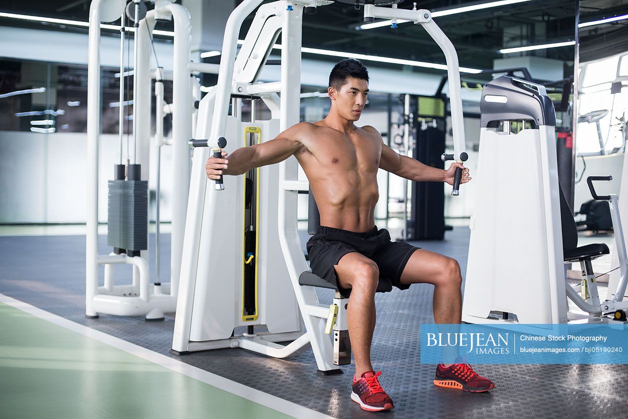 Young Chinese man exercising at gym