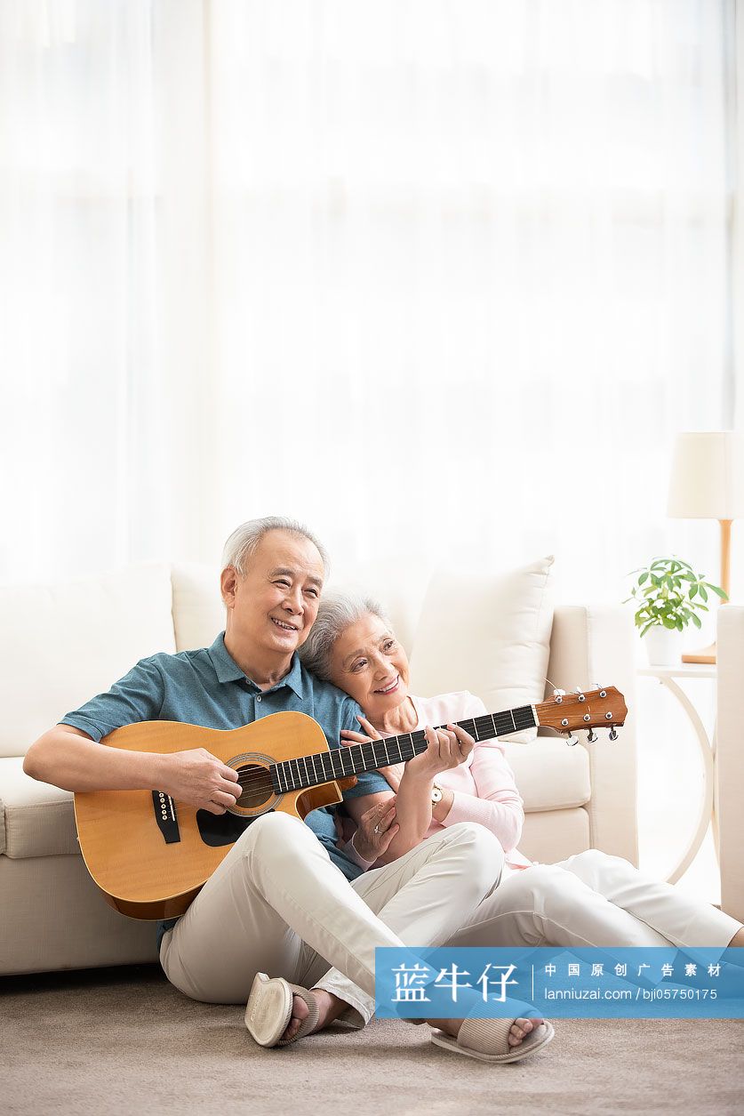 快乐的老年夫妇在客厅弹吉他