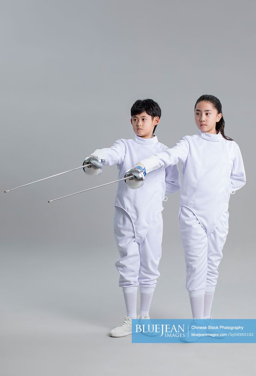 Cute Chinese girl and boy in fencing suit
