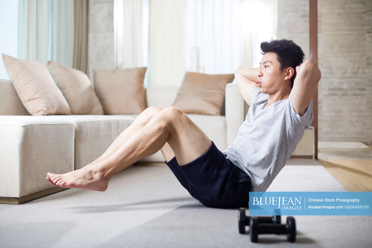 Young Chinese man exercising at home