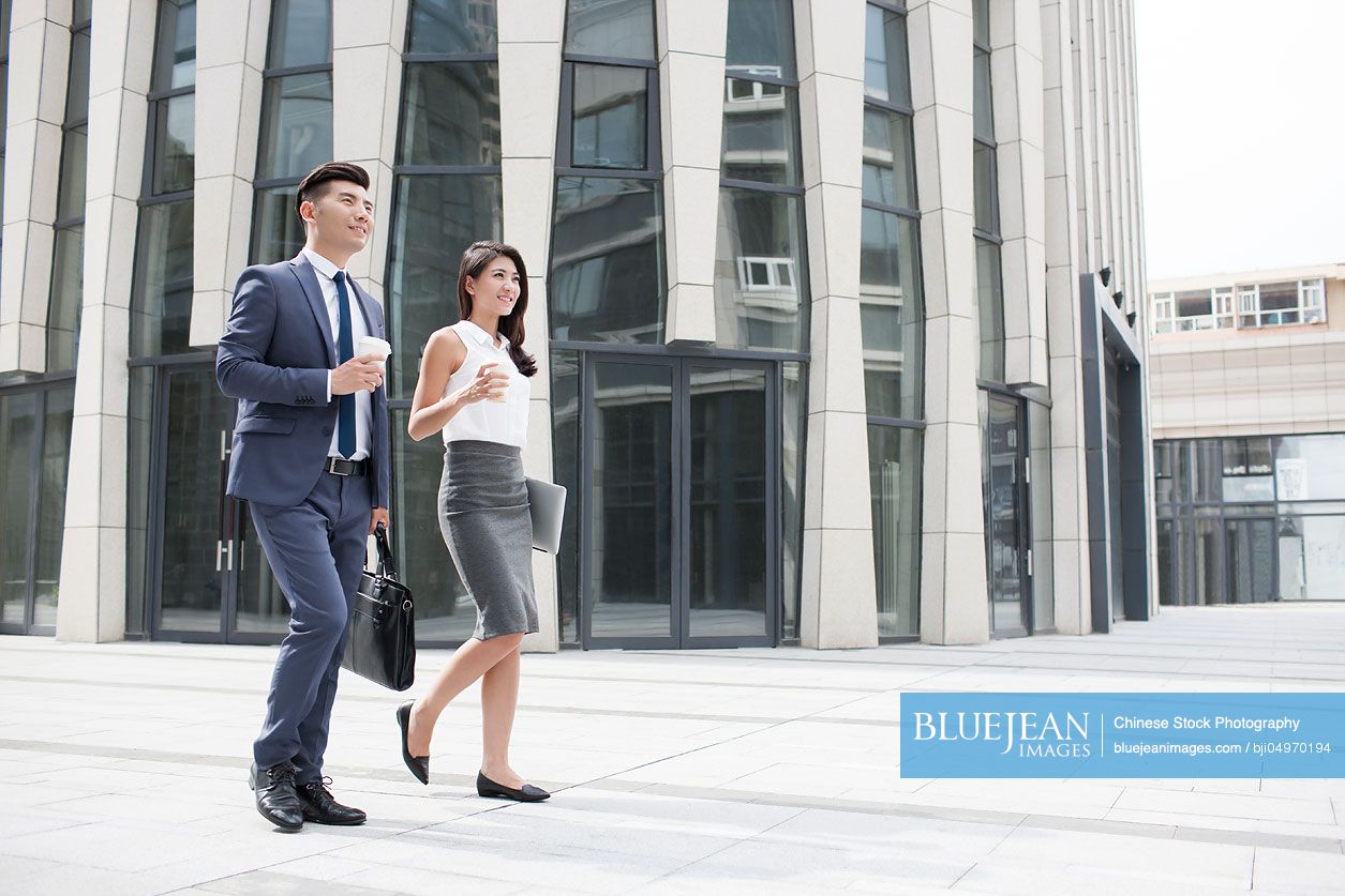 Confident Chinese business people walking outdoors