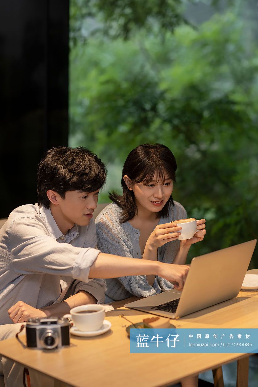 年轻情侣在咖啡馆使用笔记本电脑-蓝牛仔影像-中国原创广告影像素材