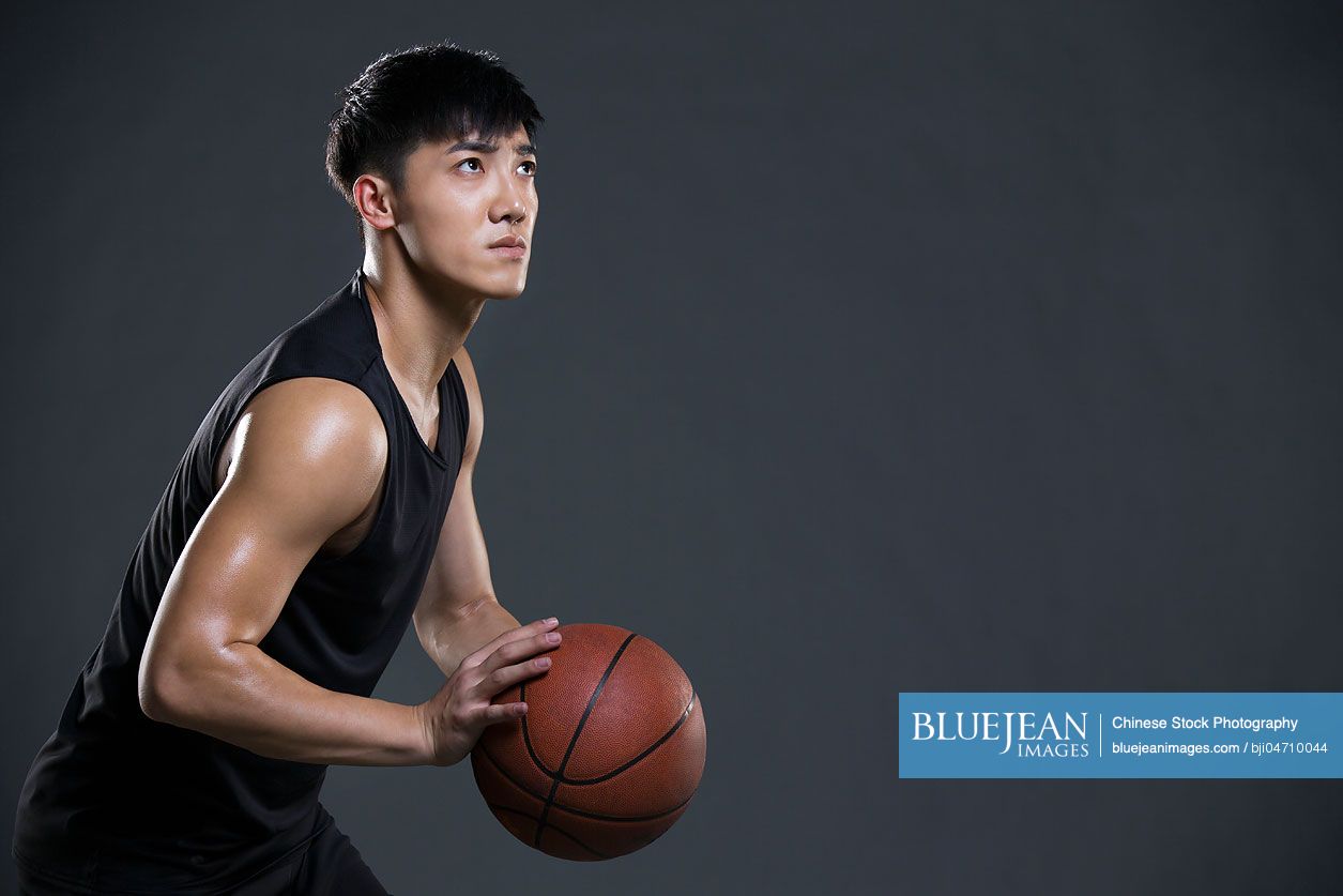 Young Chinese man playing basketball