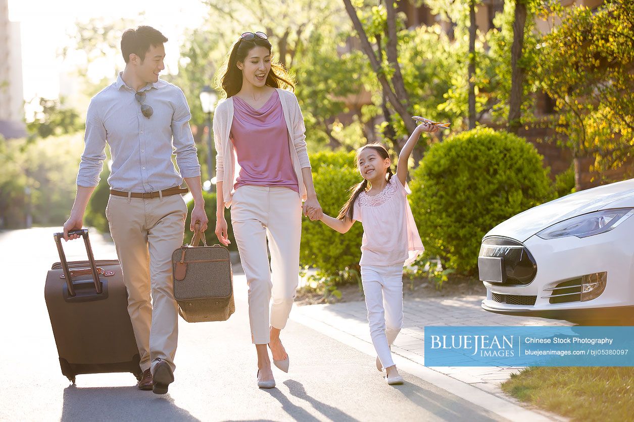 Happy young Chinese family going for vacation