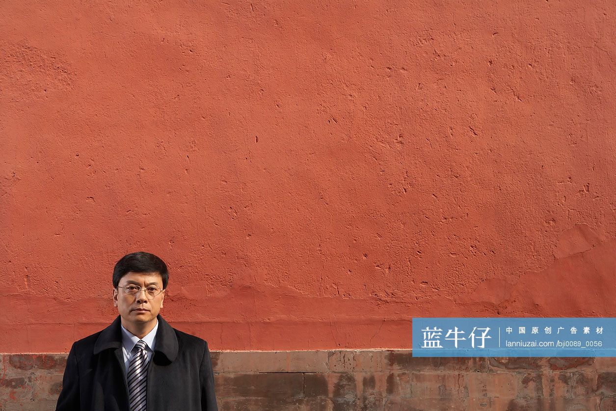 商务男士站在宫墙下