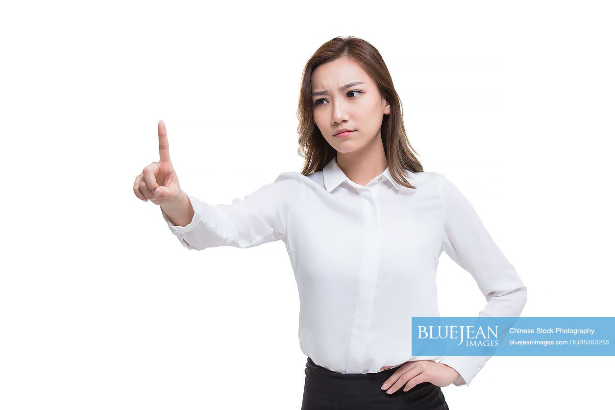 Serious young Chinese businesswoman pointing