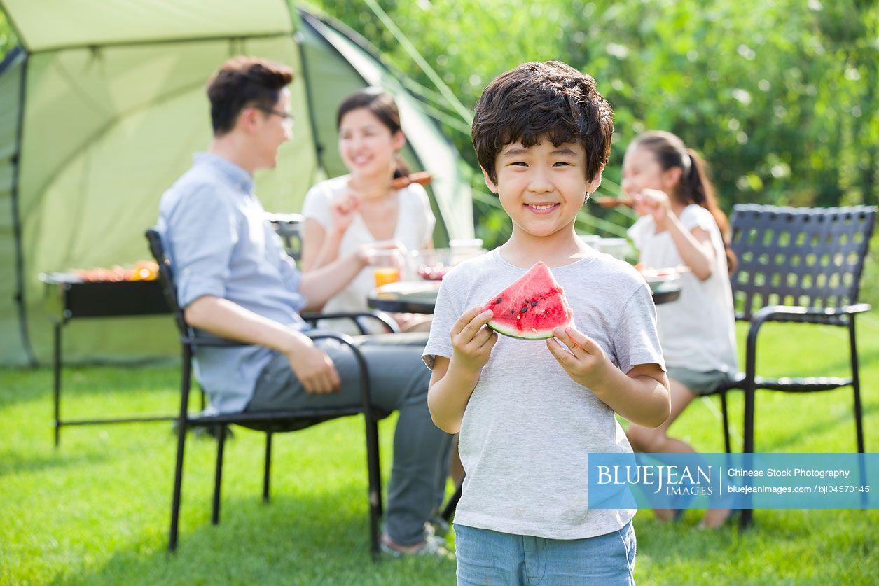 Young Chinese family picnicking outdoors