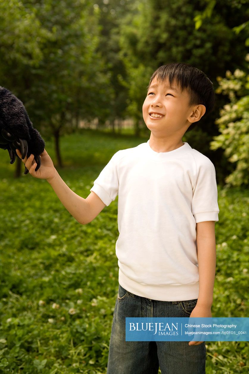 Young Chinese Boy Holding An Animal Paw