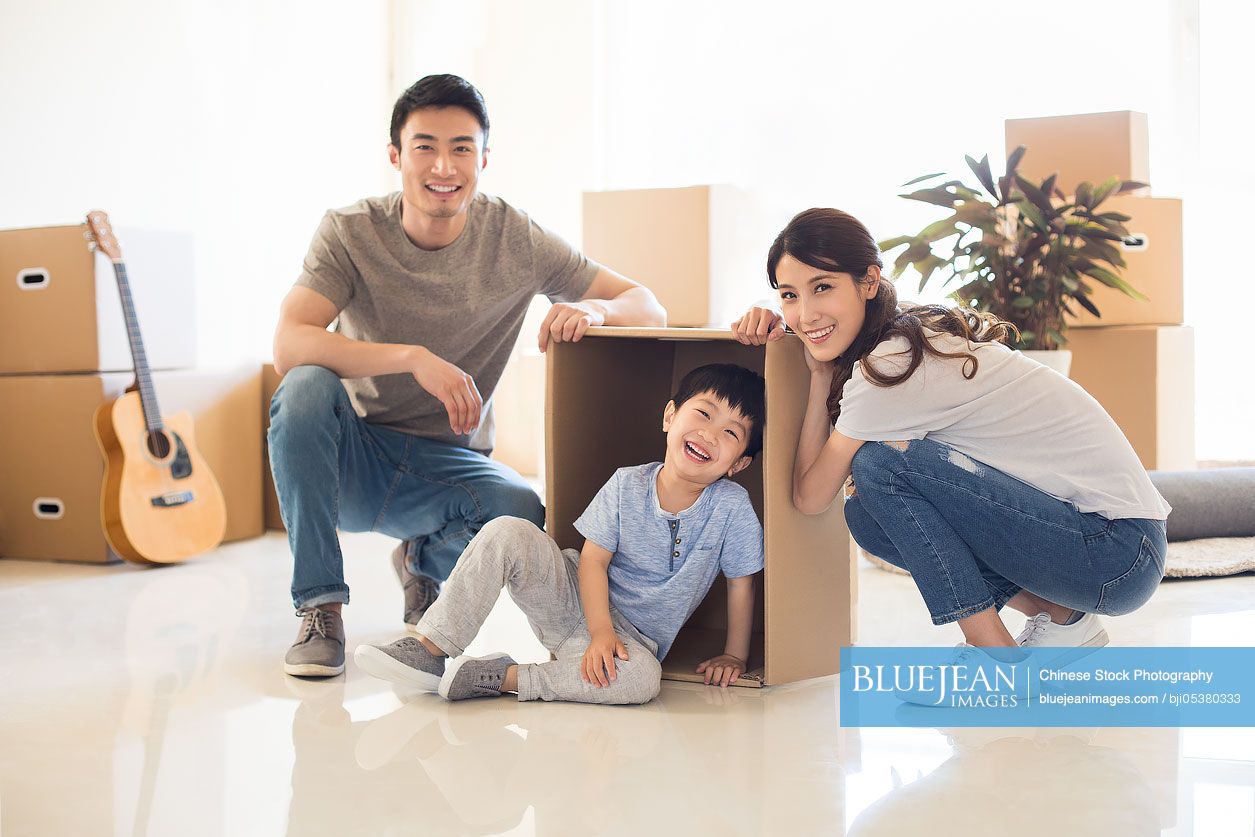 Happy young Chinese family moving to a new house