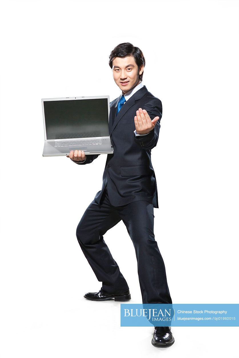 Chinese businessman in fighting stance holding laptop
