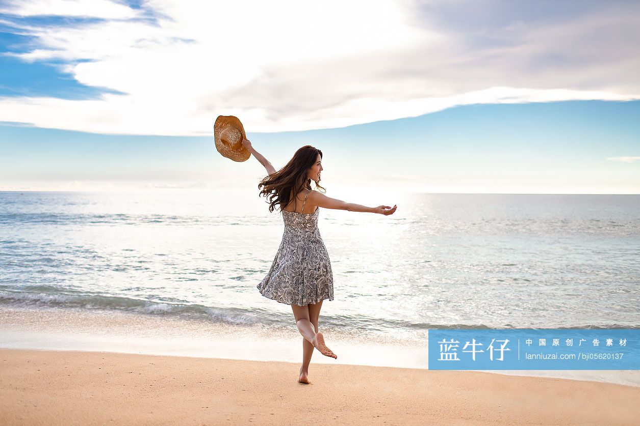 快乐的年轻女性在海边跳舞