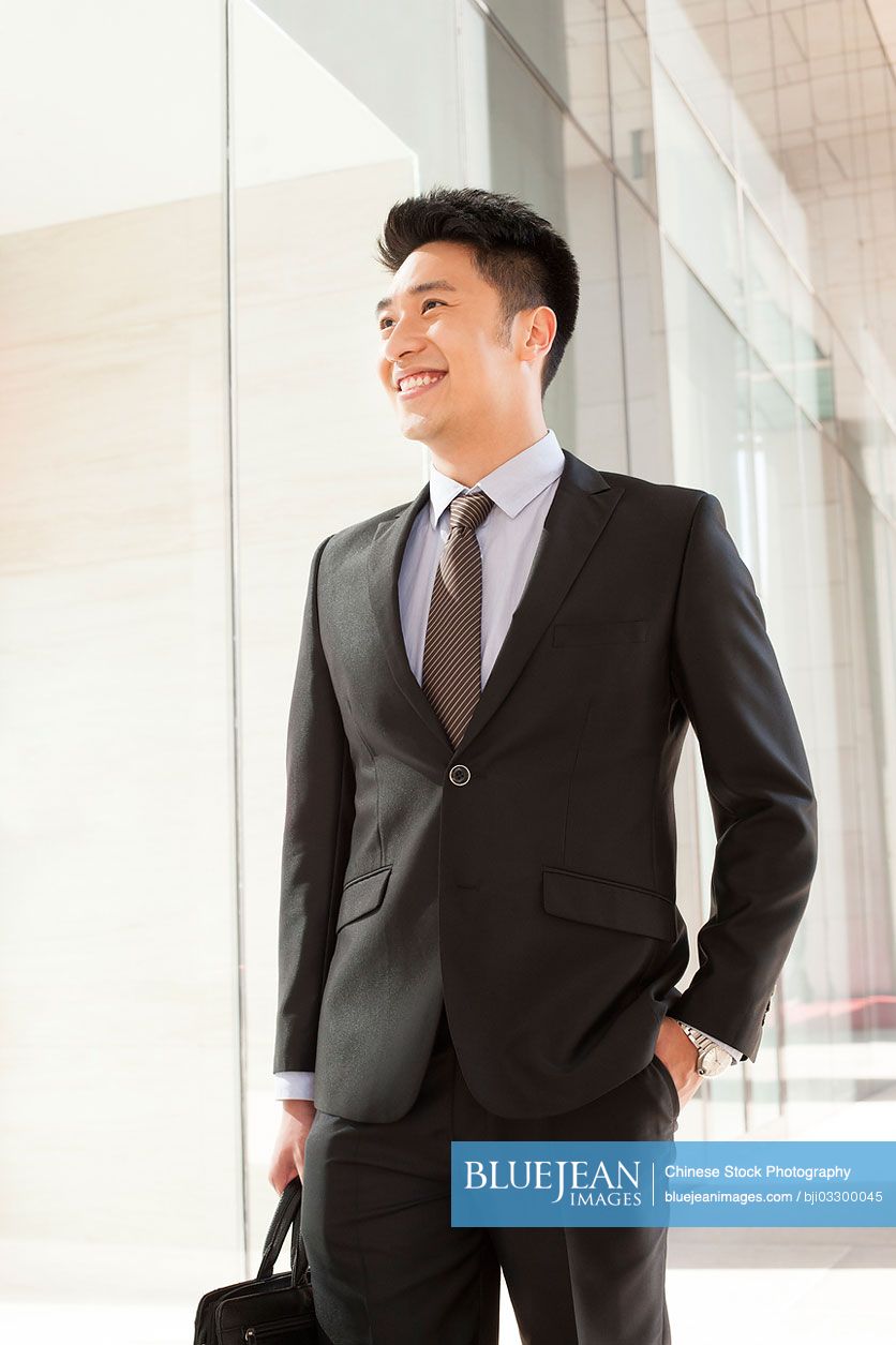 Professional Chinese businessman hands in pocket in CBD