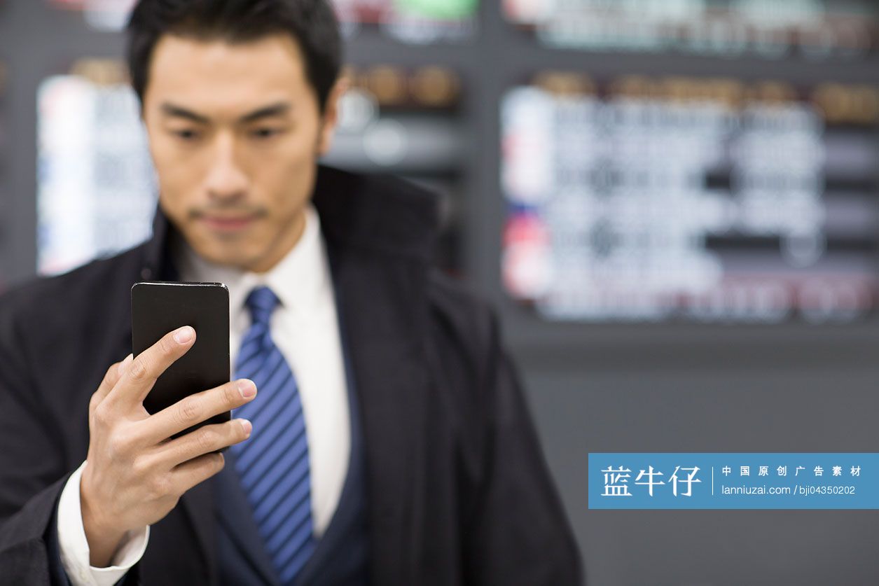 年轻商务男士在机场使用手机
