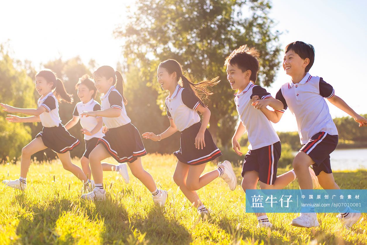 快乐的小学生在草地上奔跑
