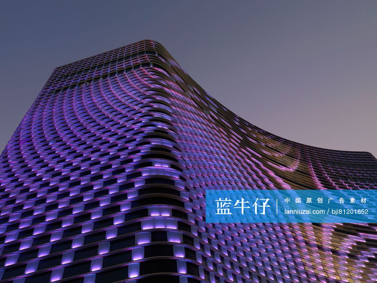 Low angle view of illuminated hotel building with purple lighting at dusk