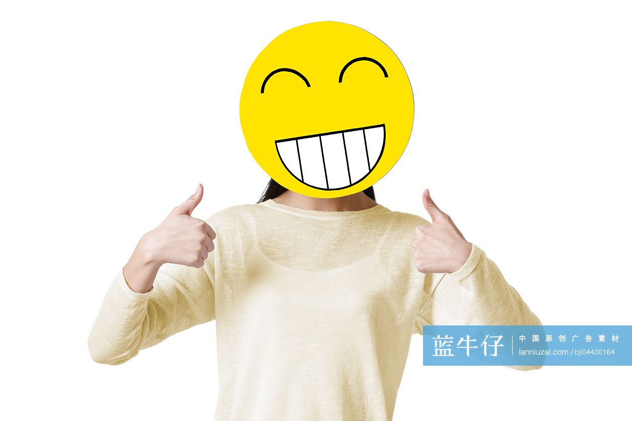 年轻女子戴着一张卡通笑脸竖起大拇指