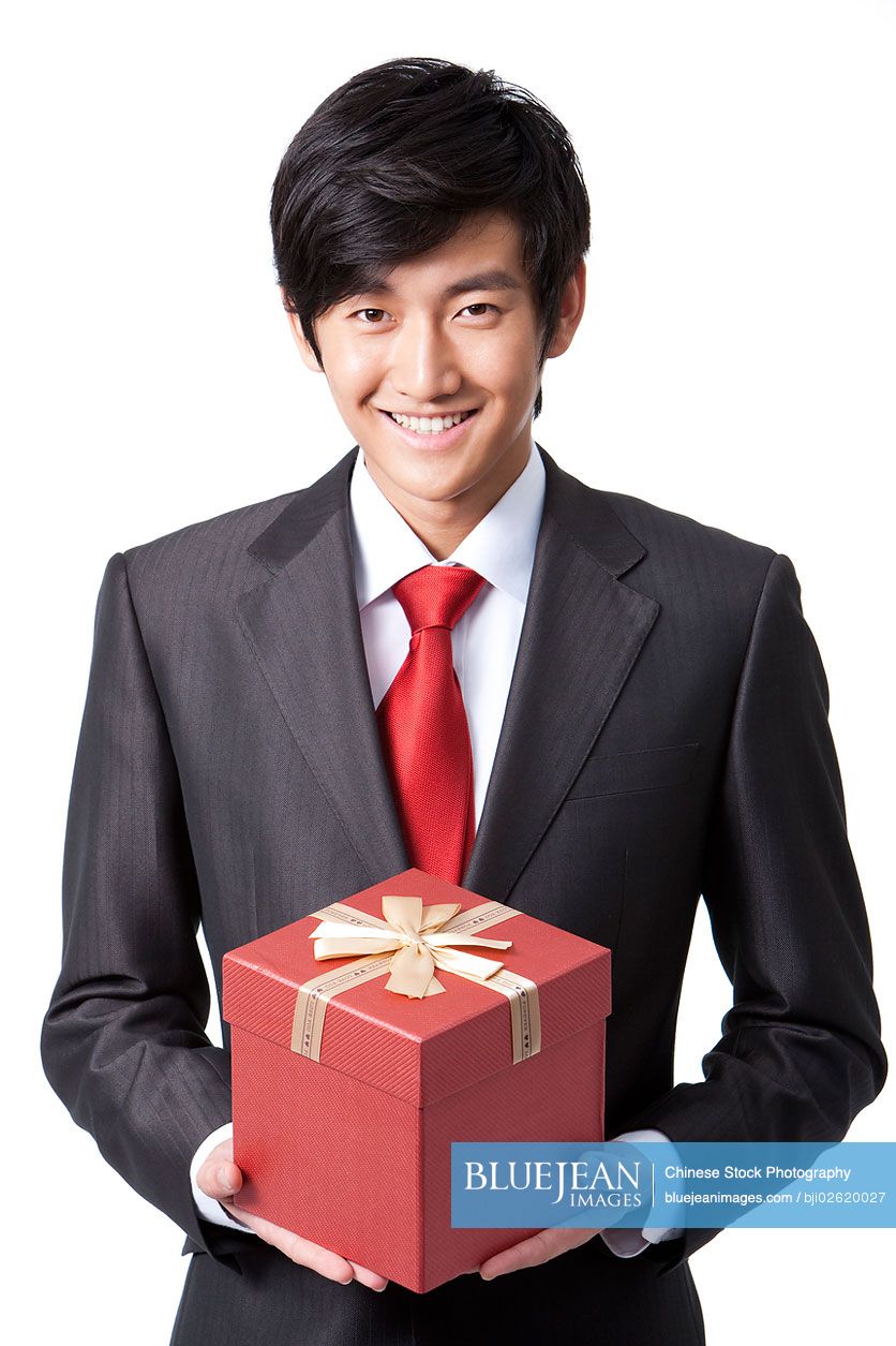 Happy Chinese businessman holding a gift