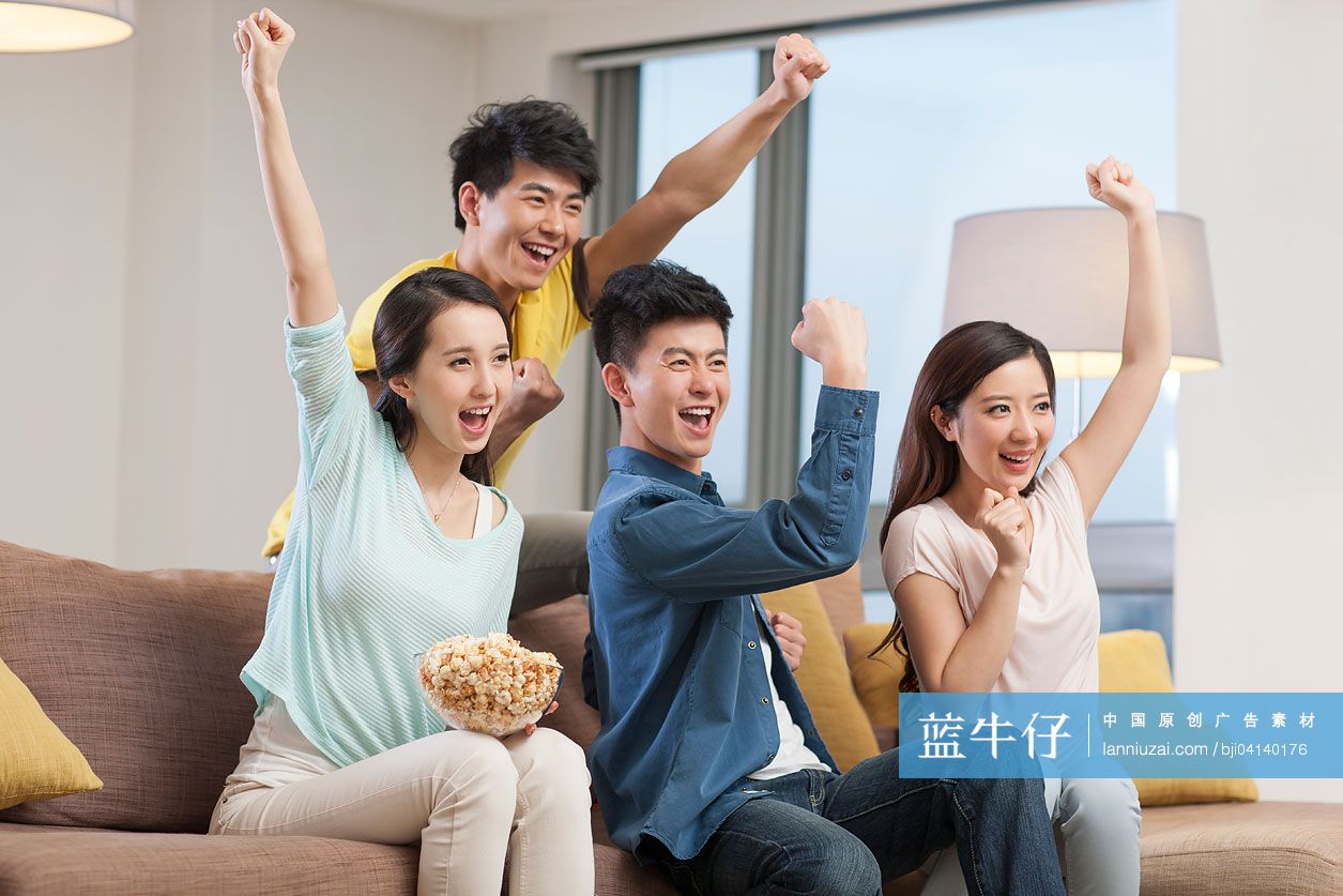 年轻人在客厅一起看体育比赛