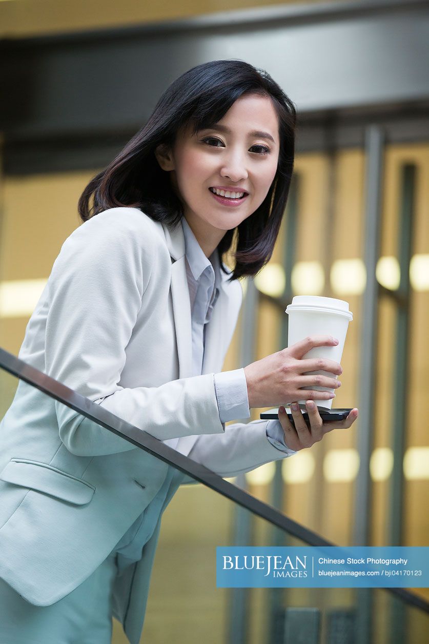 Portrait of young Chinese businesswoman with coffee cup