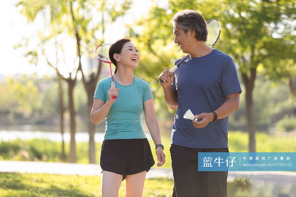 开心的中老年夫妇在户外打羽毛球