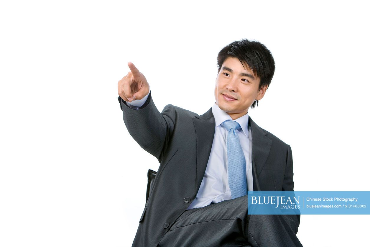 Young Chinese businessman pointing by finger