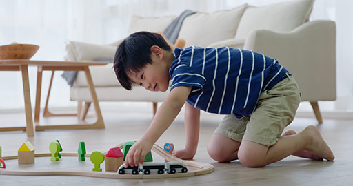 快乐的小男孩在客厅玩火车玩具