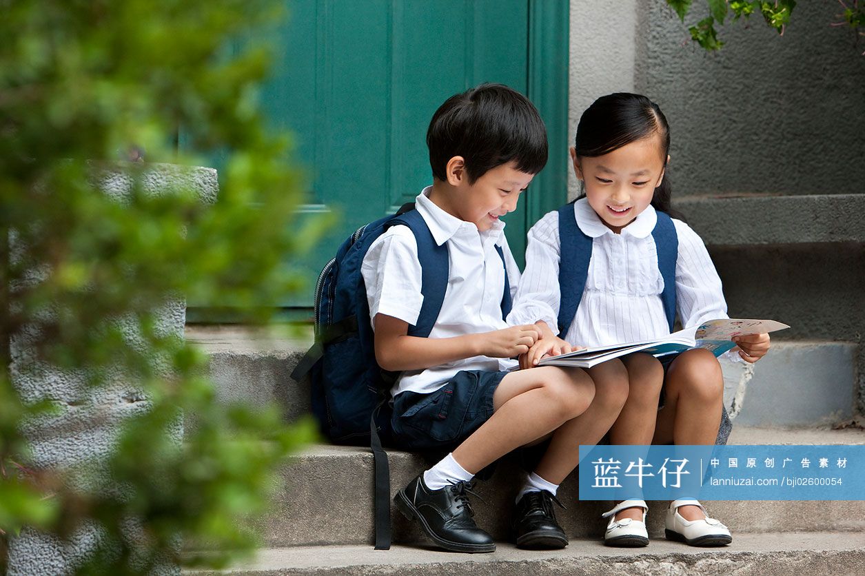 儿童坐在普通社区门口台阶上