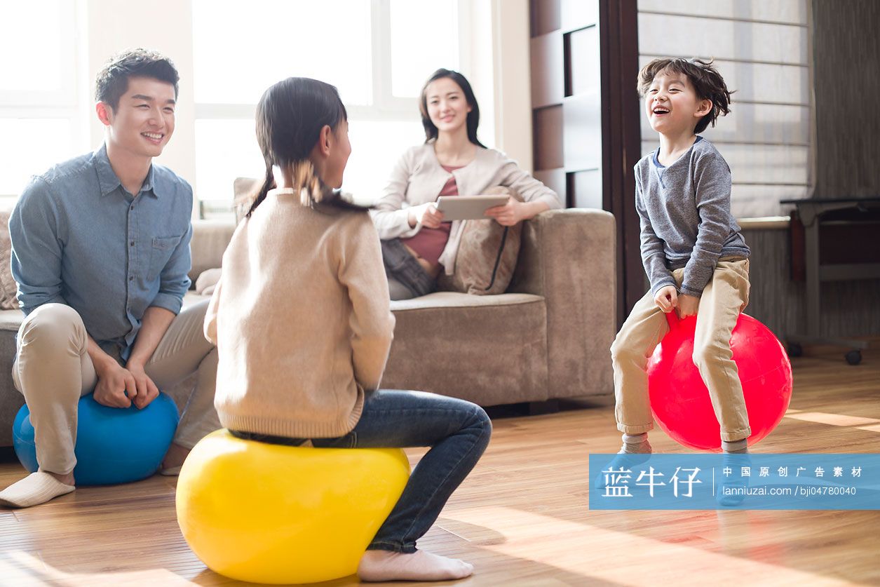 快乐的年轻家庭玩跳跳球