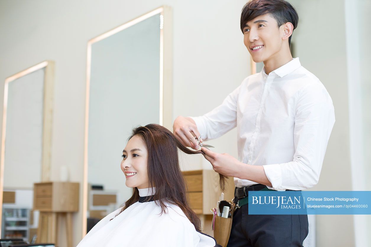 Chinese barber cutting customer's hair