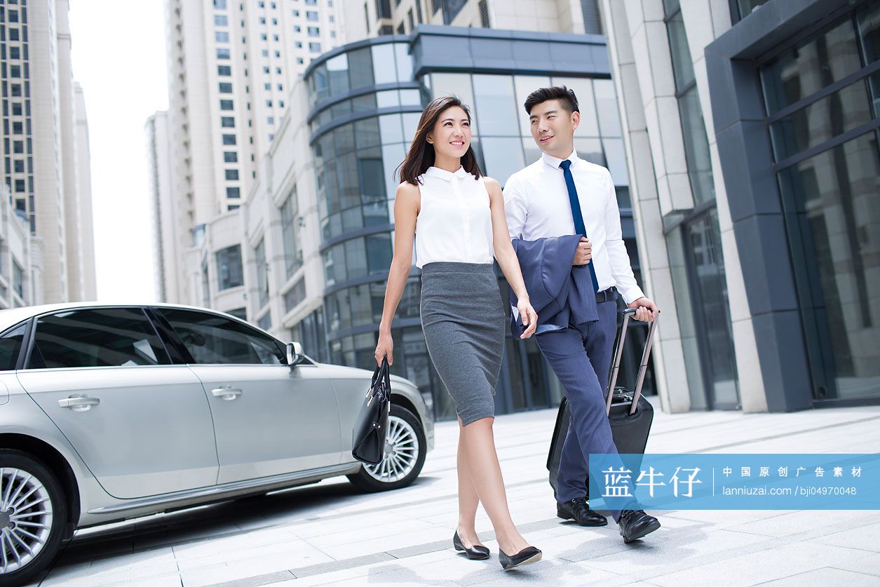 自信的商务人士拉着行李箱走路