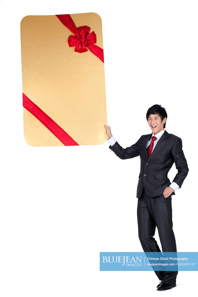 Excited Chinese businessman holding an oversized wrapped card