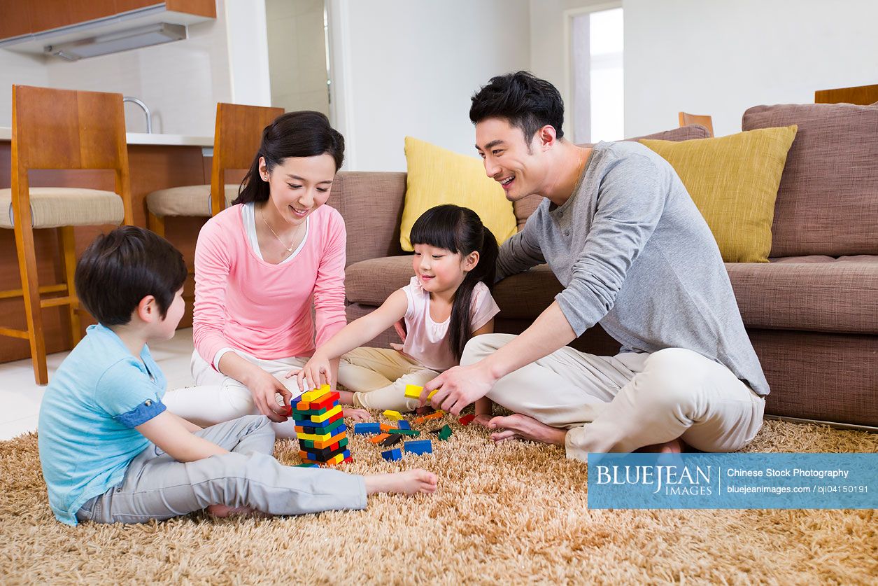 Happy Chinese family playing building blocks