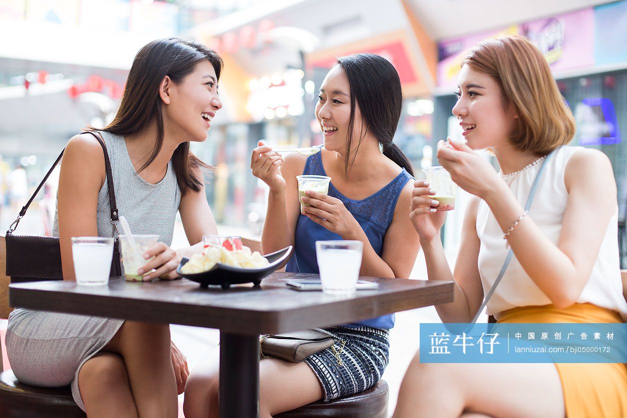 年轻闺蜜在露天咖啡馆聊天